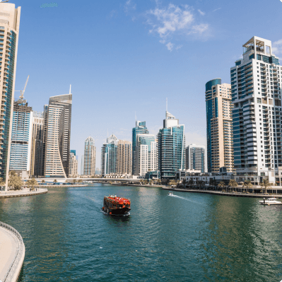 A tour boat passing the towers of Dubai Marina by day