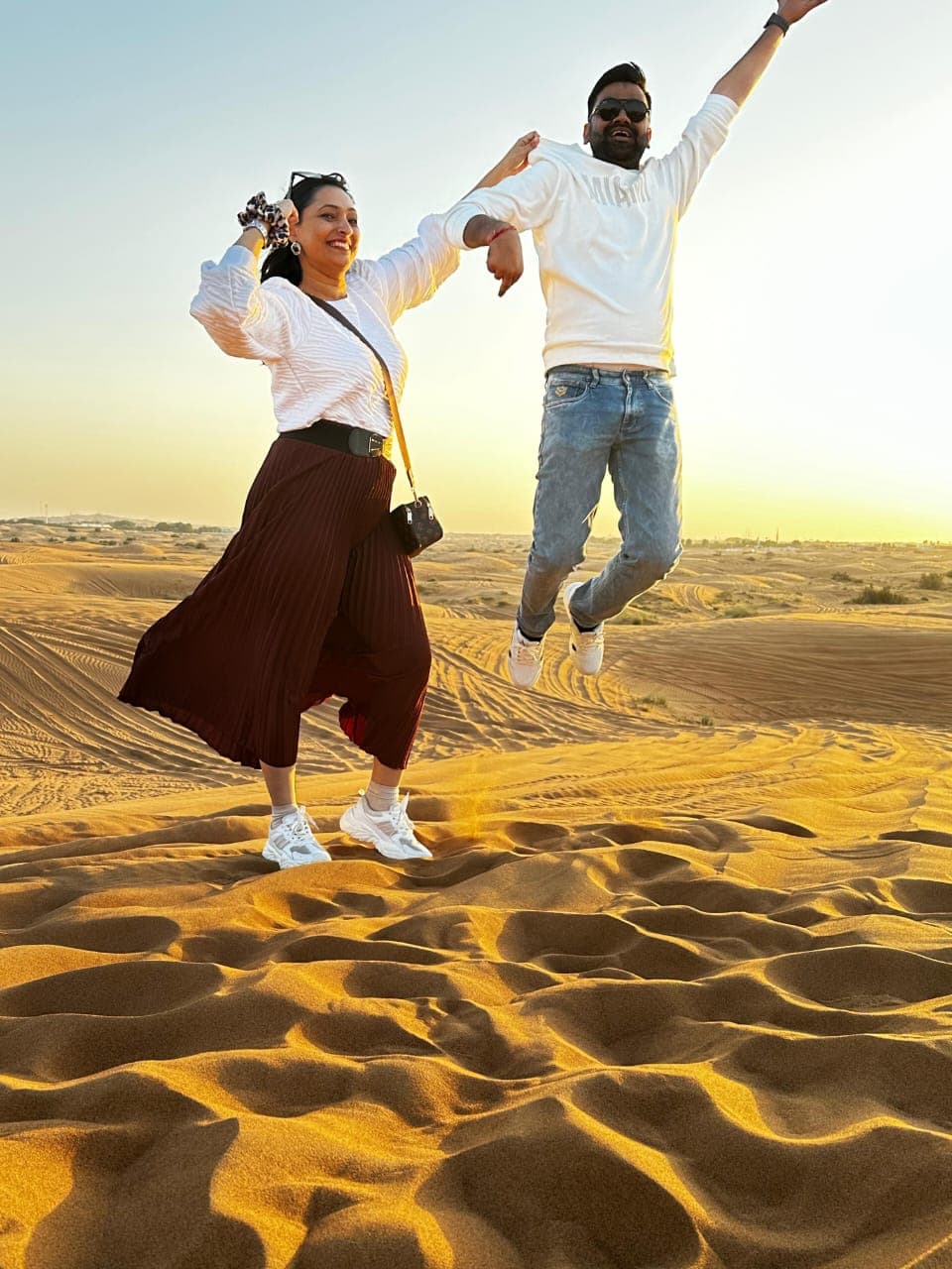Guests jumping together during a sunset desert safari