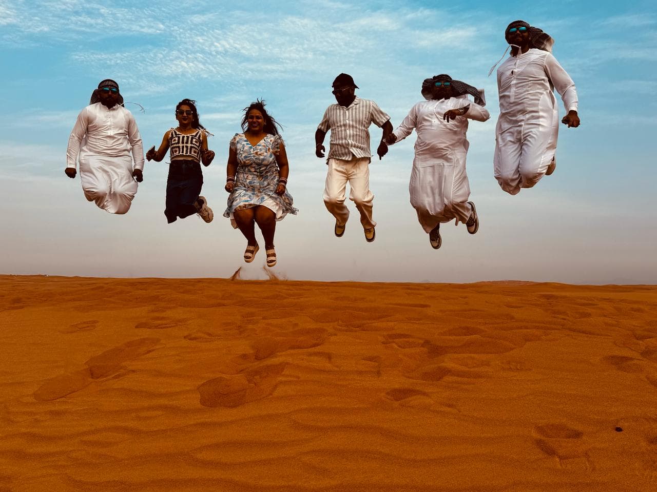 A group celebrating together in the Dubai desert
