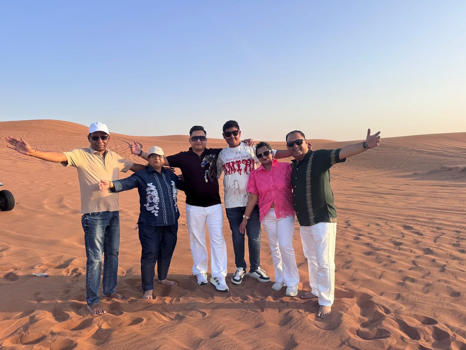 A group of friends posing together in the Dubai desert