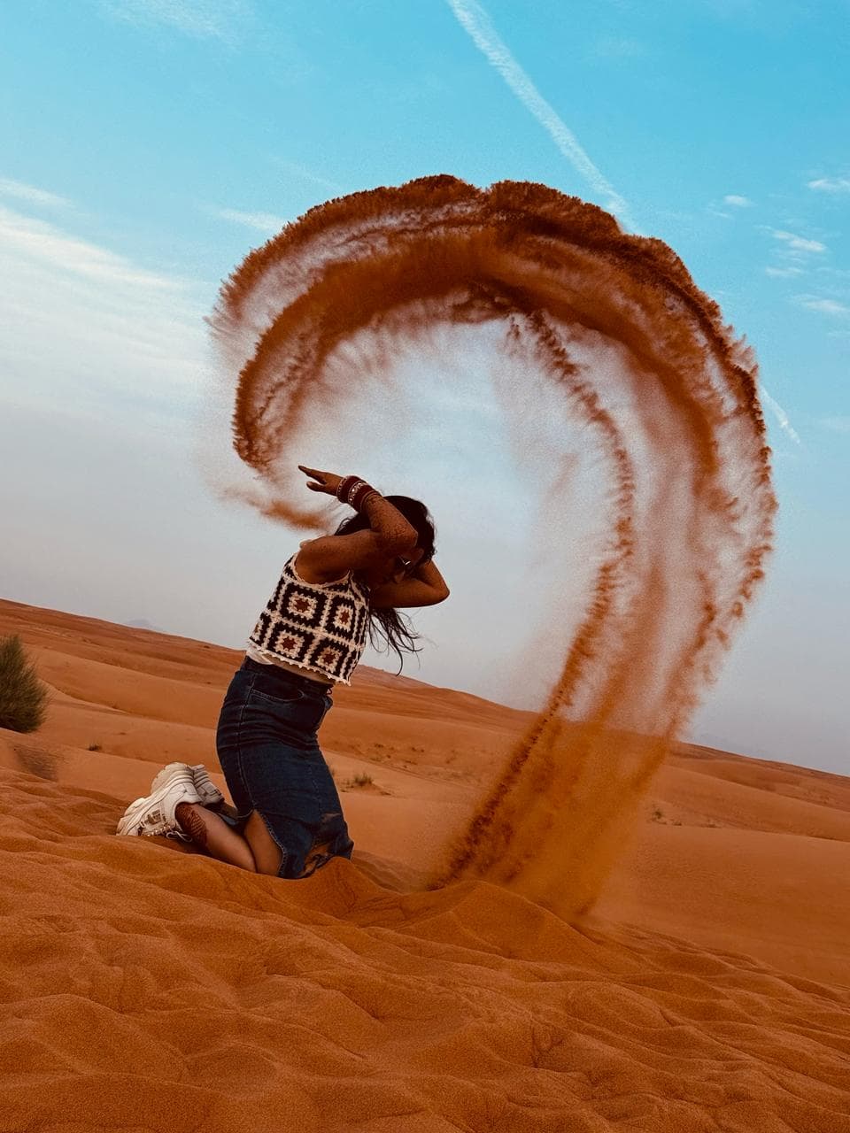 A traveller making a dramatic sand arc on the dunes