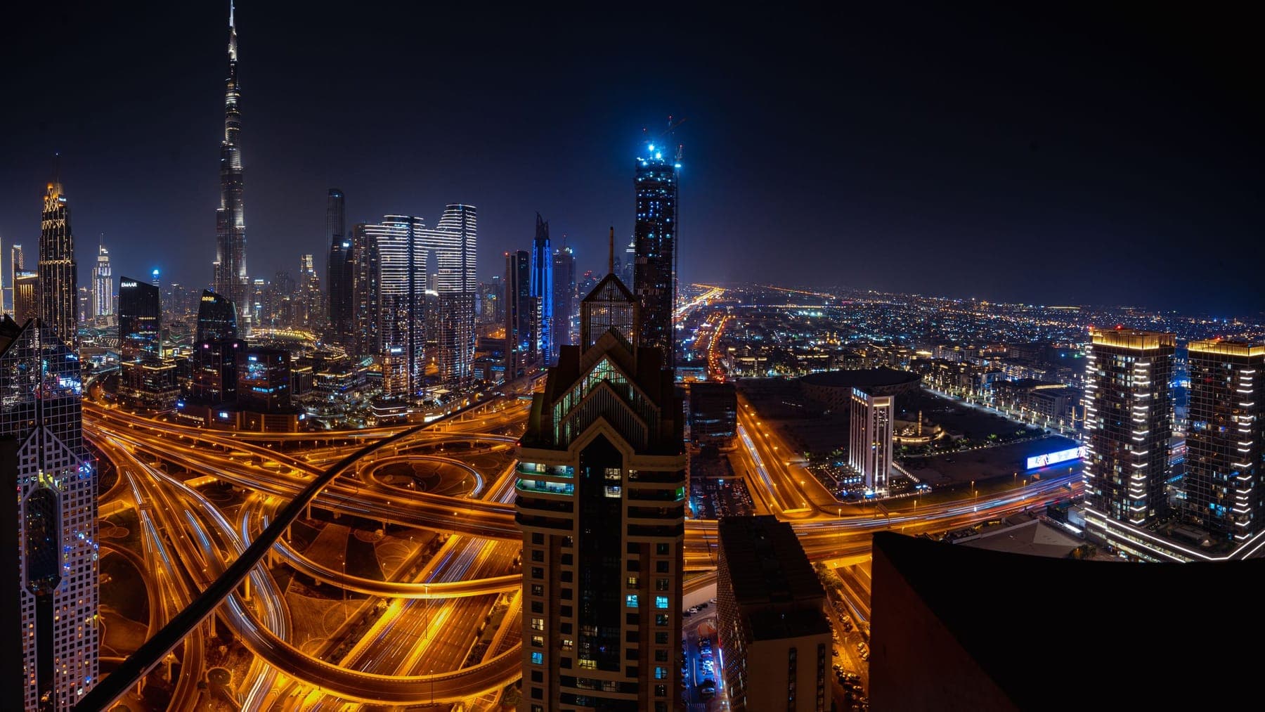 Sheikh Zayed Road at night, traffic threading between the towers