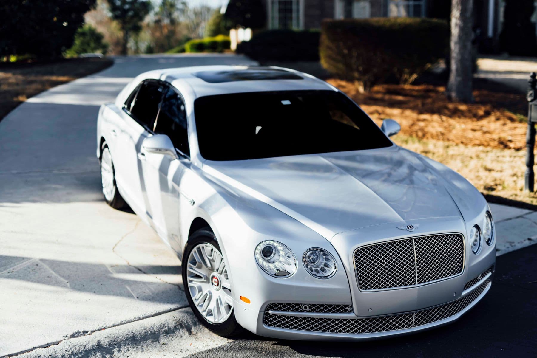A silver Bentley sedan in a residential setting