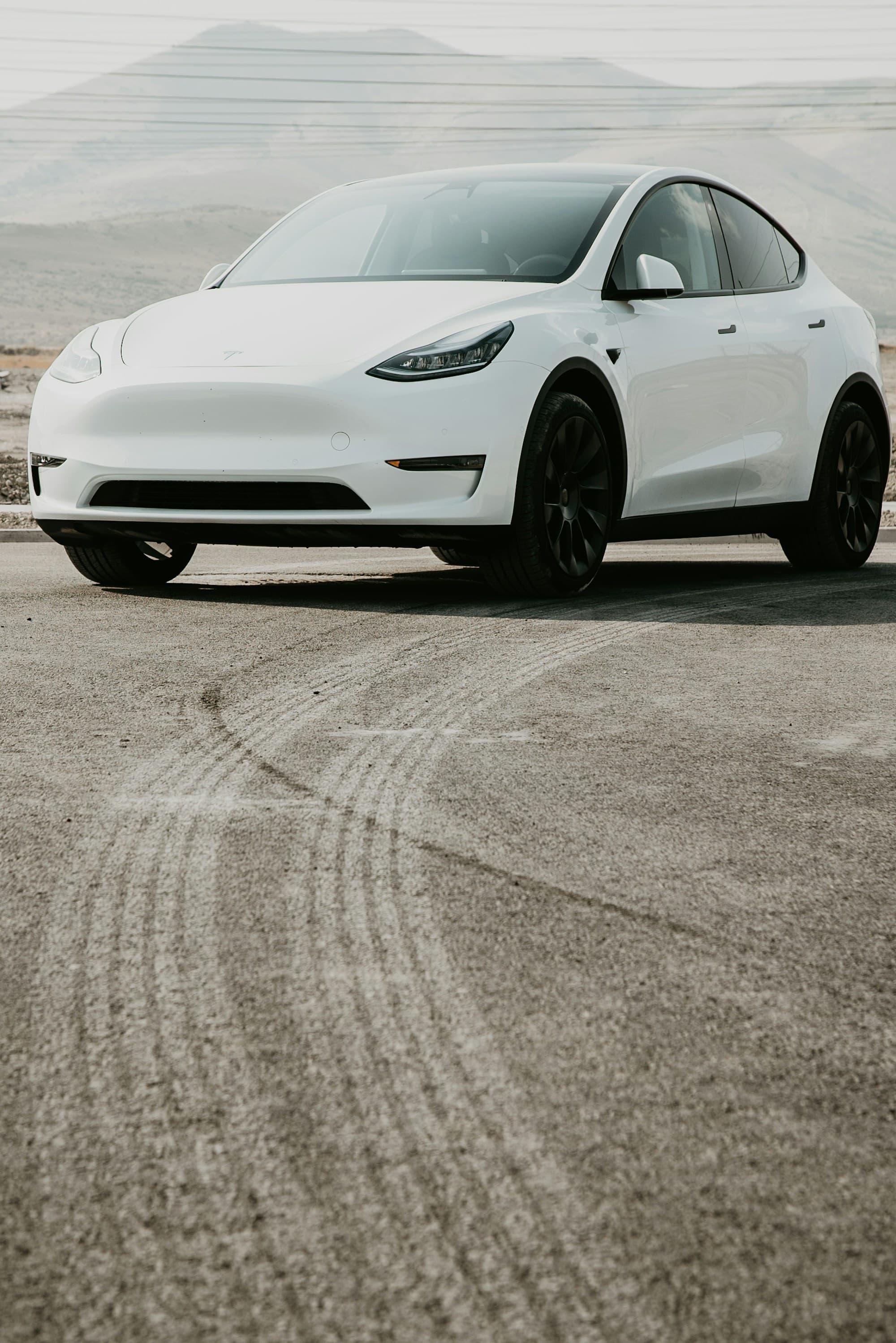 A white Tesla Model Y on a desert road